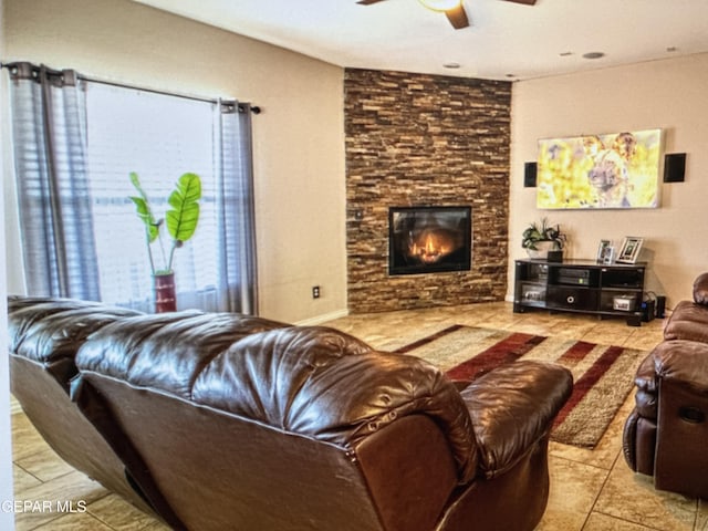 living room featuring ceiling fan, a fireplace, and light tile patterned flooring