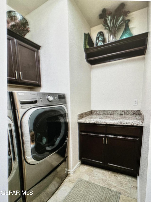 washroom featuring washer and dryer and cabinets