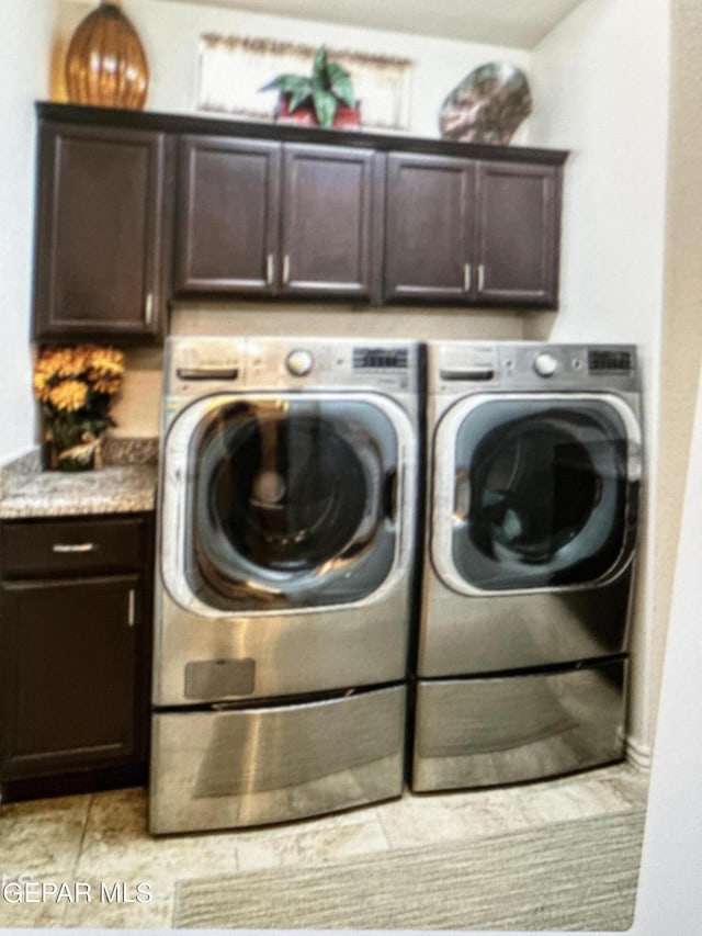 laundry room featuring light tile patterned floors, cabinets, and independent washer and dryer