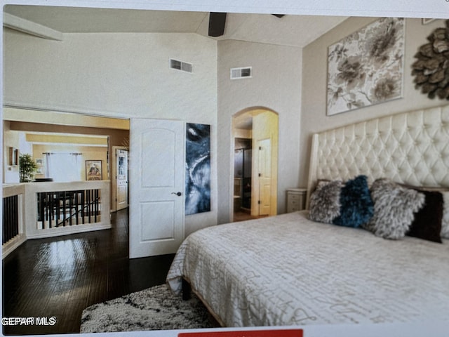 bedroom with ceiling fan, lofted ceiling, and dark wood-type flooring