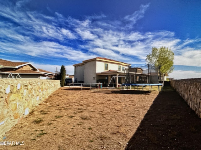 back of house featuring a trampoline