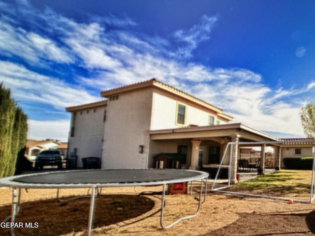 rear view of house with a trampoline