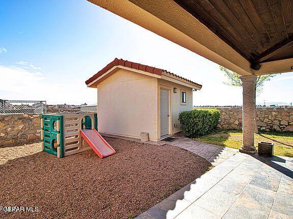 exterior space with an outbuilding, a patio, and a playground