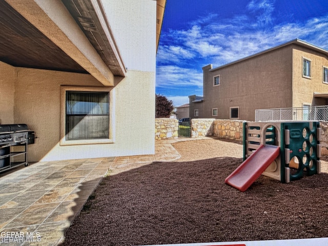 view of jungle gym featuring a patio