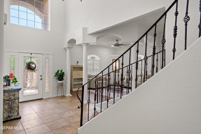 tiled entryway featuring a high ceiling, ceiling fan, and ornate columns