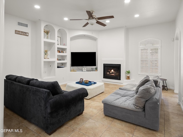 living room featuring light tile patterned flooring, built in features, and ceiling fan