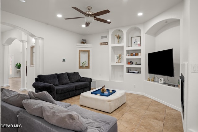 tiled living room with ceiling fan, built in features, and decorative columns