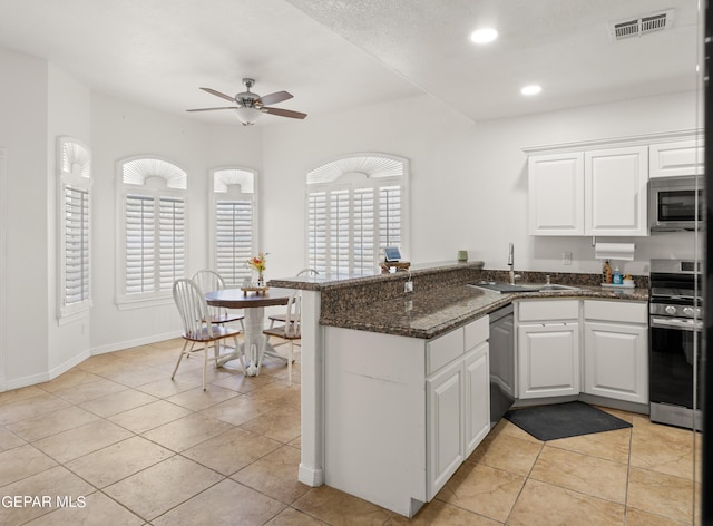 kitchen with white cabinets, sink, appliances with stainless steel finishes, and kitchen peninsula