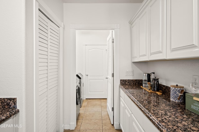 laundry area with washer / clothes dryer and light tile patterned flooring