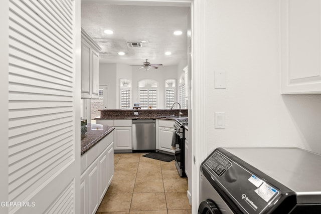 kitchen featuring a textured ceiling, washer / dryer, white cabinets, appliances with stainless steel finishes, and sink