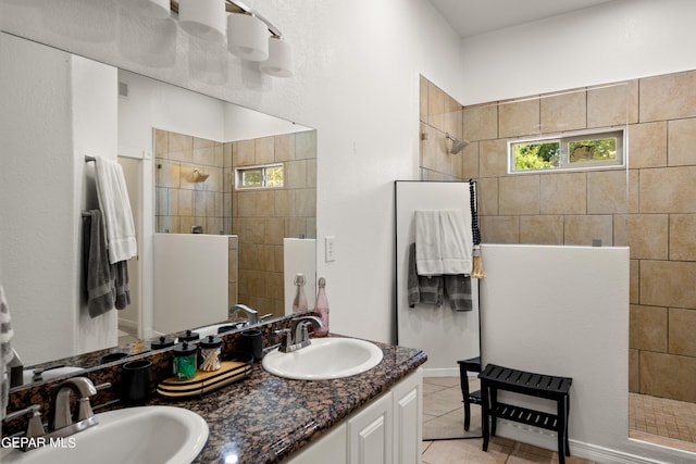 bathroom featuring vanity, a tile shower, and tile patterned floors