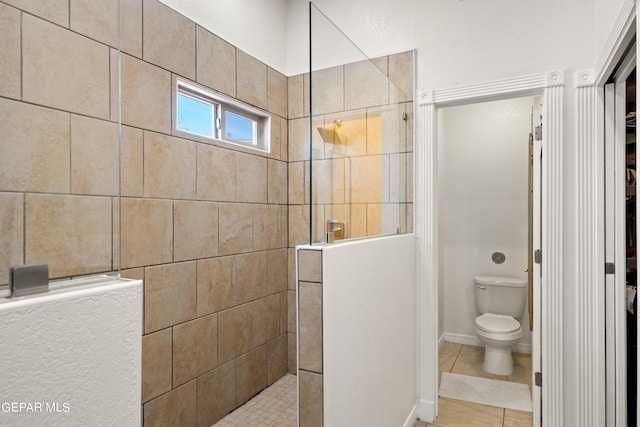 bathroom with tiled shower, tile patterned floors, and toilet