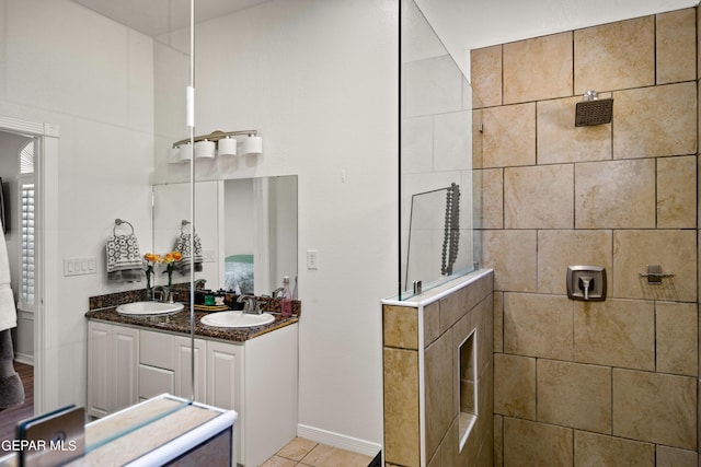 bathroom with a tile shower and vanity