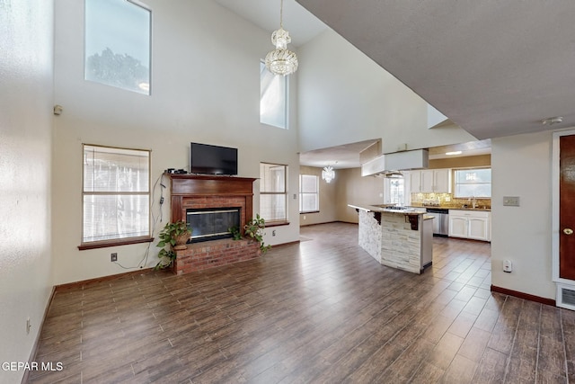 kitchen with decorative light fixtures, a kitchen bar, a brick fireplace, an inviting chandelier, and white cabinets