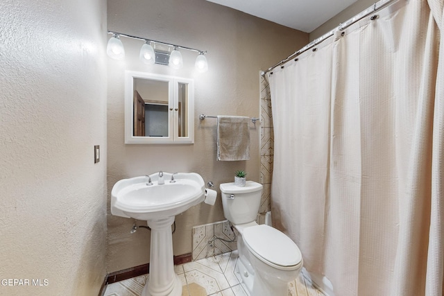 bathroom featuring toilet, tile patterned floors, and walk in shower