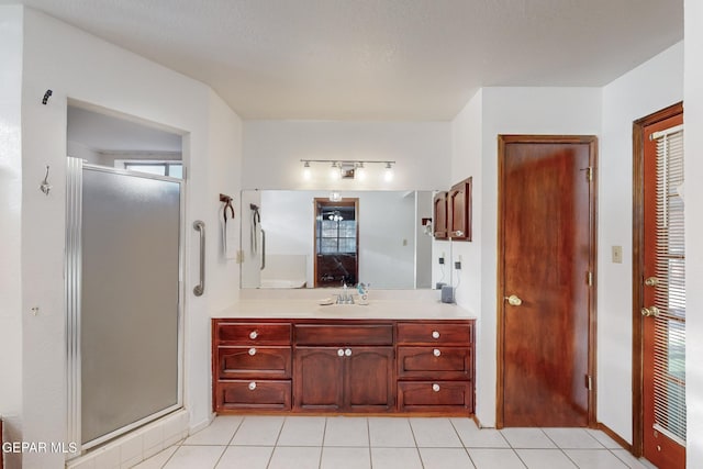 bathroom with tile patterned flooring, an enclosed shower, and vanity