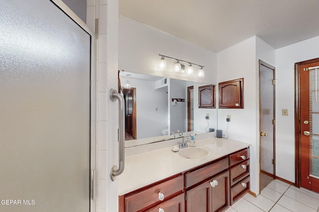 bathroom with tile patterned flooring, an enclosed shower, and vanity