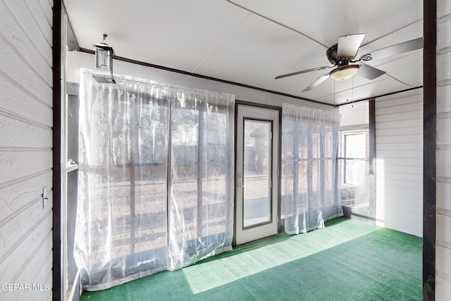 unfurnished sunroom with ceiling fan