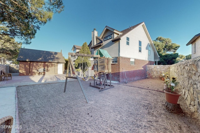 back of property with an outbuilding and a patio