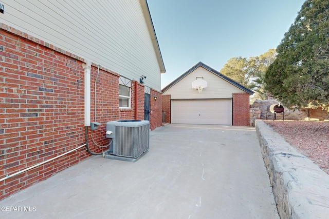 view of home's exterior with a garage, an outbuilding, and central AC unit