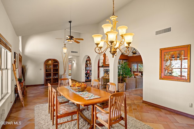 dining area featuring ceiling fan with notable chandelier and high vaulted ceiling