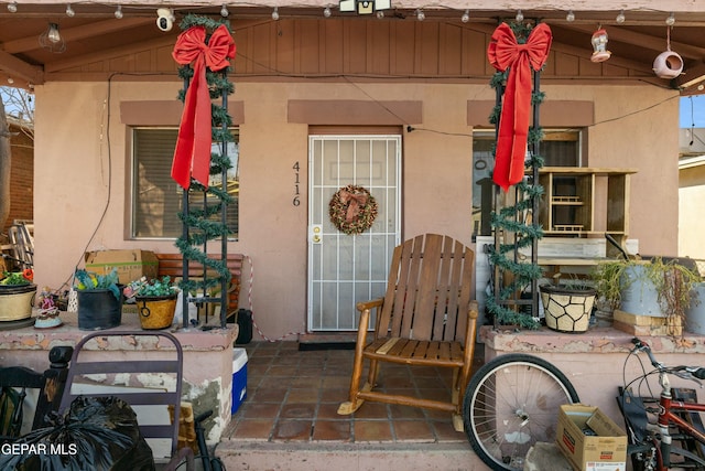 view of exterior entry with a patio area