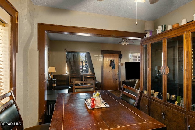 dining area featuring ceiling fan and a textured ceiling