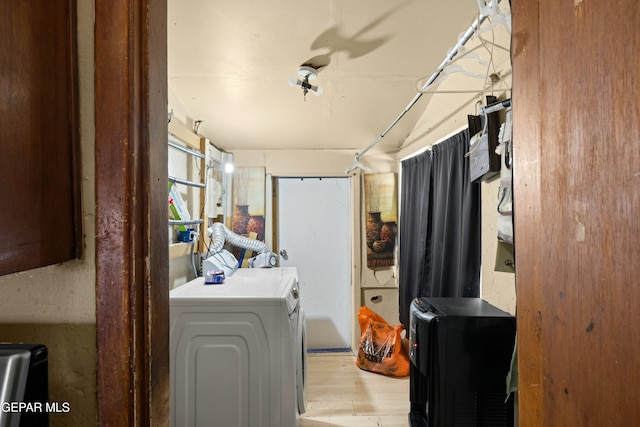 laundry room with washer and clothes dryer and light hardwood / wood-style flooring