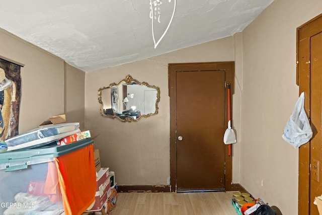 interior space with light wood-type flooring and vaulted ceiling