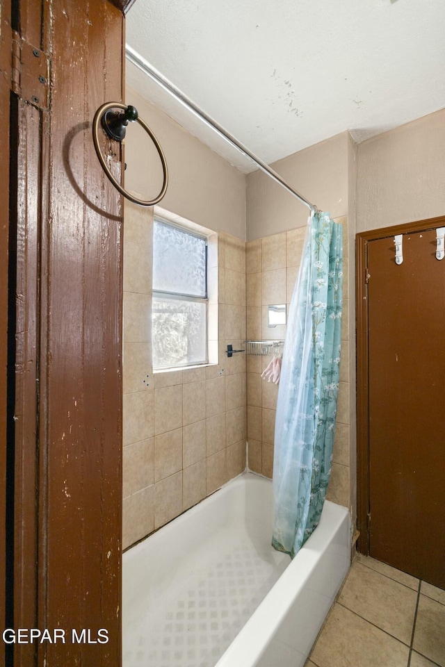 bathroom with tile patterned flooring and shower / tub combo with curtain