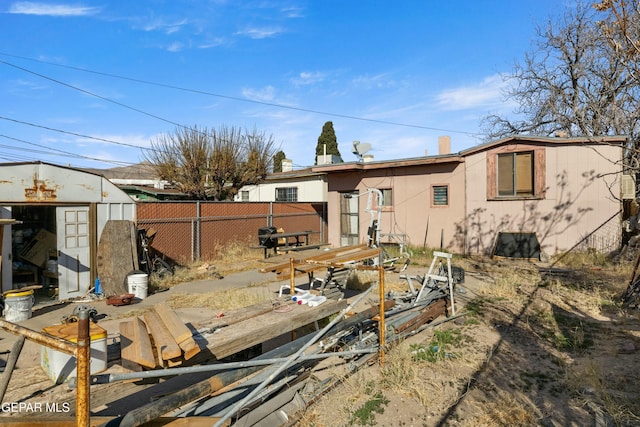 rear view of house featuring a storage unit