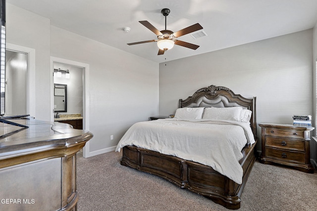 carpeted bedroom with ensuite bath and ceiling fan