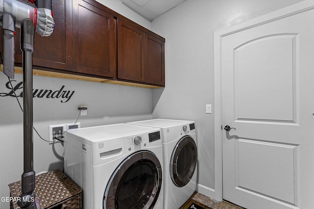 washroom with cabinets and washer and clothes dryer