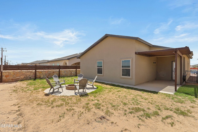 rear view of house with a fire pit and a patio