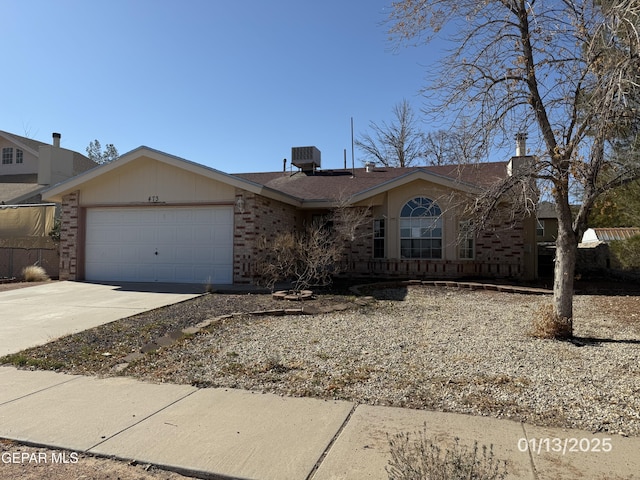 single story home with cooling unit and a garage