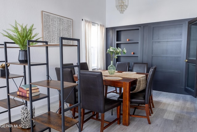 dining space featuring an inviting chandelier, hardwood / wood-style flooring, and built in features