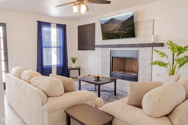 living room with ceiling fan, a fireplace, and wood-type flooring