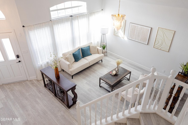 living room featuring an inviting chandelier, hardwood / wood-style floors, and a healthy amount of sunlight