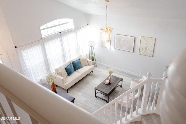 living room featuring high vaulted ceiling, hardwood / wood-style floors, and a notable chandelier