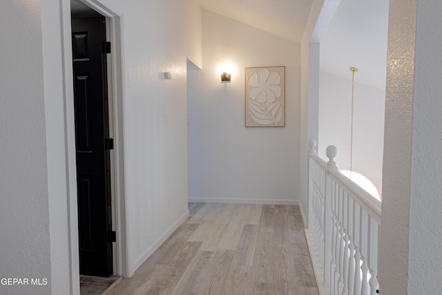 hall featuring light hardwood / wood-style floors and lofted ceiling