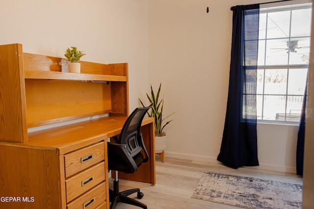 home office with light hardwood / wood-style flooring