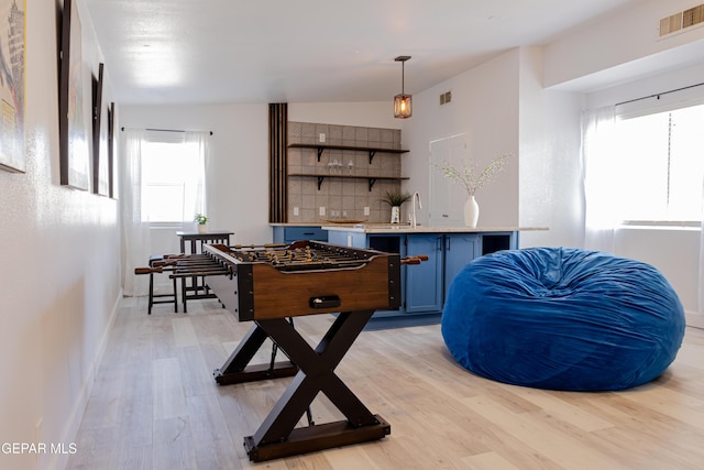 game room featuring light wood-type flooring and lofted ceiling