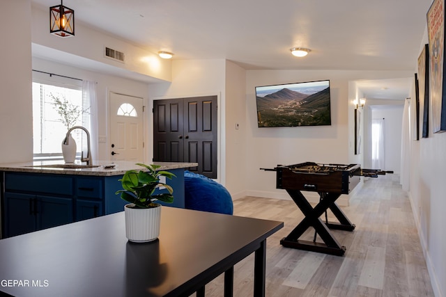 dining room featuring sink, light hardwood / wood-style flooring, and lofted ceiling