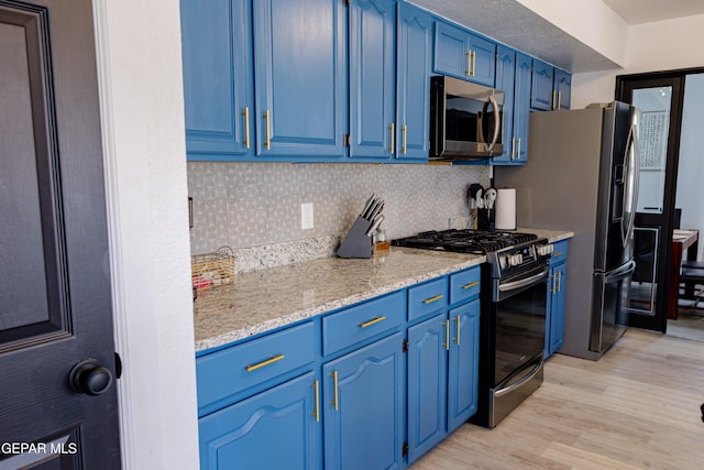 kitchen featuring light hardwood / wood-style floors, blue cabinetry, backsplash, and appliances with stainless steel finishes