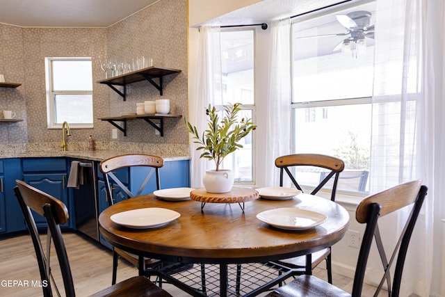 dining room with sink, ceiling fan, and light hardwood / wood-style floors