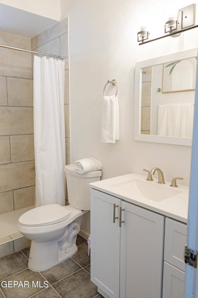 bathroom featuring curtained shower, tile patterned flooring, vanity, and toilet