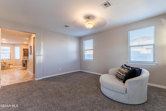 living area featuring carpet and ceiling fan