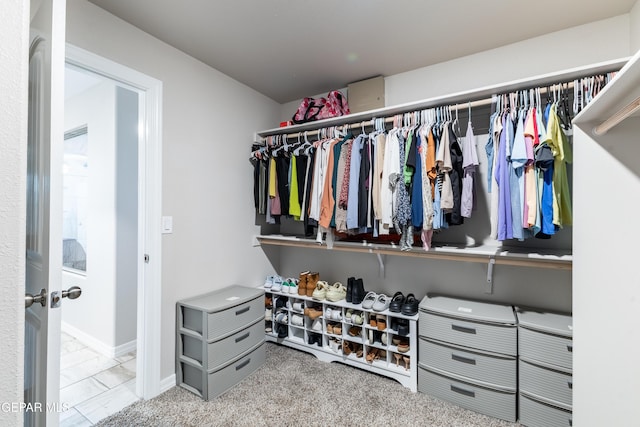 walk in closet featuring light colored carpet