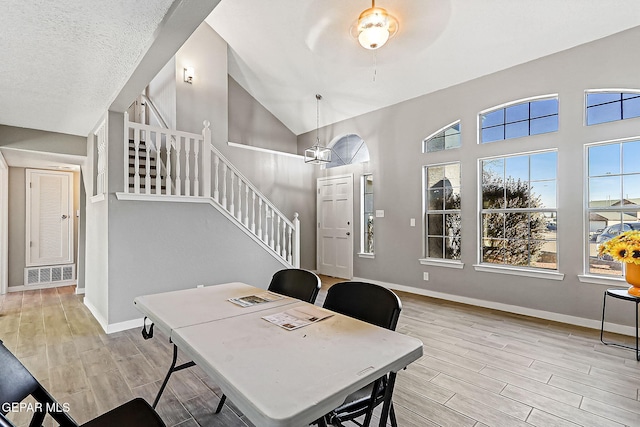 home office with ceiling fan, high vaulted ceiling, and a textured ceiling