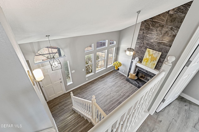 entrance foyer featuring hardwood / wood-style flooring, a fireplace, and an inviting chandelier